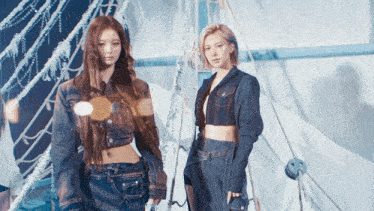two women standing next to each other wearing denim jackets and skirts