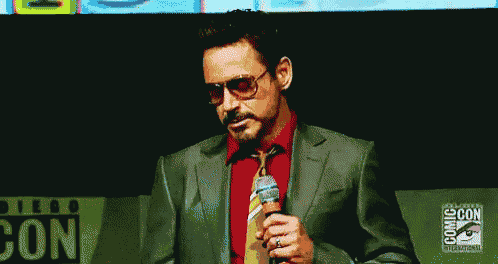 a man in a suit and tie is talking into a microphone at a convention .
