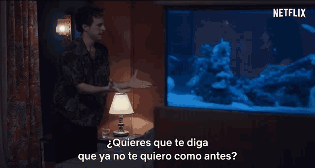a man is standing in front of a fish tank with netflix written on the bottom