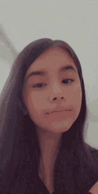 a close up of a girl 's face with long hair and a pink lip