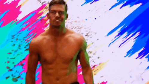 a shirtless man is standing in front of a colorful background and looking at the camera .