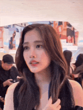 a woman in a black dress is standing in a crowd