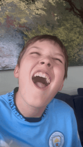 a young boy wearing a blue shirt that says city on it