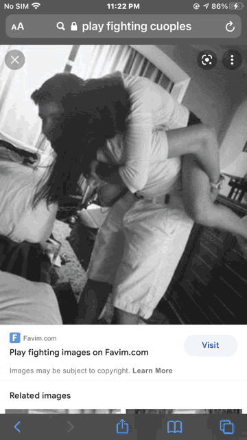 a phone screen shows a picture of a man carrying a woman over his shoulders