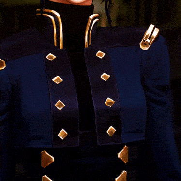a woman in a blue jacket with gold buttons on the sleeves