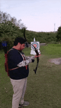 a man is holding a bow and arrow in front of a target that says ' arrow ' on it