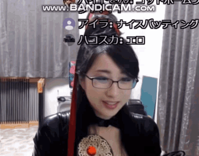 a woman wearing glasses is smiling in front of a screen that says www.banditcam.com