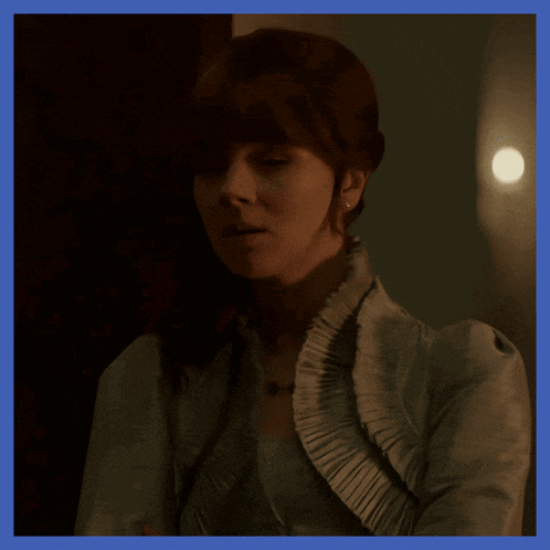 a woman wearing a white jacket with ruffles on the collar