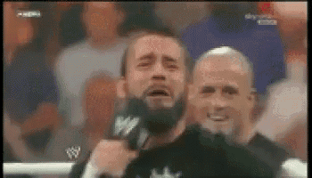 a man with a beard is crying while holding a microphone with a w logo