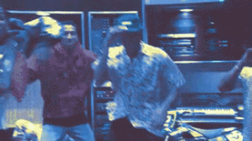 a blurry picture of two men dancing with one wearing a shirt that says ' snoop dogg ' on it