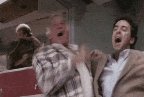 two men are standing next to each other with their mouths open in a room .