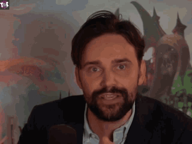 a man with a beard is saying you 're in front of a dragon