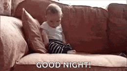 a baby is sitting on a couch with the words `` good night '' written on the couch .