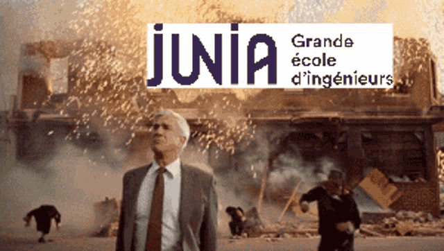 a man in a suit and tie stands in front of a building that is on fire and says junia