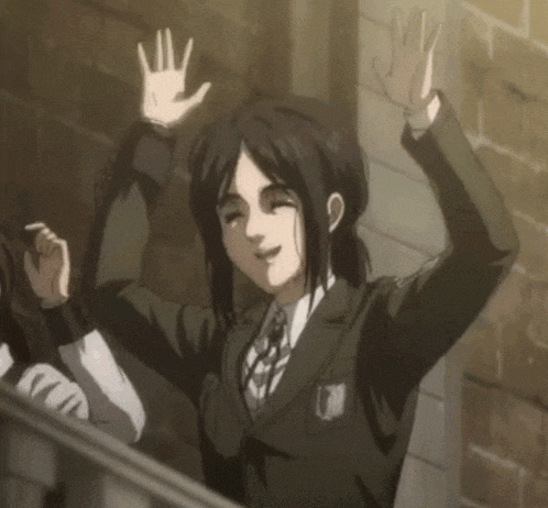 a woman in a suit and tie is waving her hands in the air .