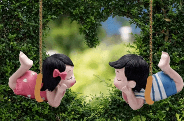 a boy and a girl are laying on swings in a tree