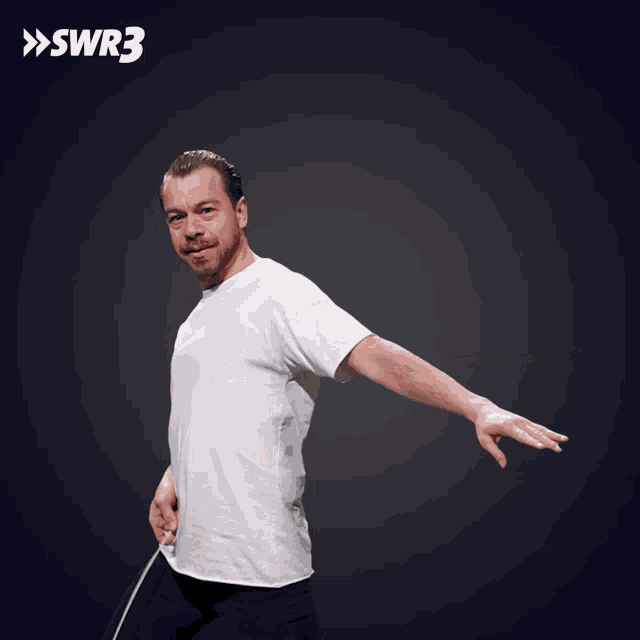 a man in a white t-shirt is throwing a frisbee with swr3 written on the bottom