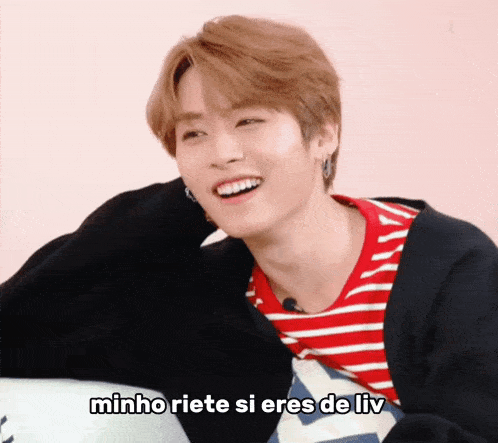 a young man wearing a red and white striped shirt is smiling with the words minho riete si eres de liv underneath him