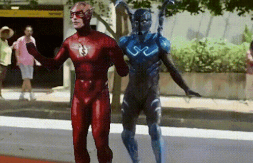 a flash and a blue beetle are standing next to each other on the street