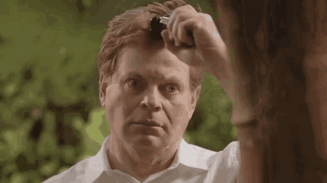 a man is brushing his hair with a comb .