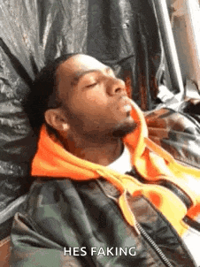 a man in a camouflage jacket is sleeping in a chair .