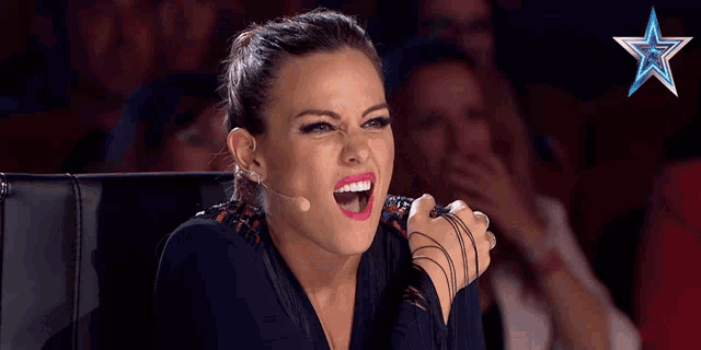 a woman is sitting in front of a microphone with a star in the background