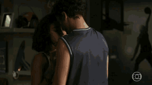 a man wearing a brooklyn jersey kisses a woman