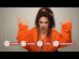 a woman wearing an orange jacket is standing with her arms outstretched