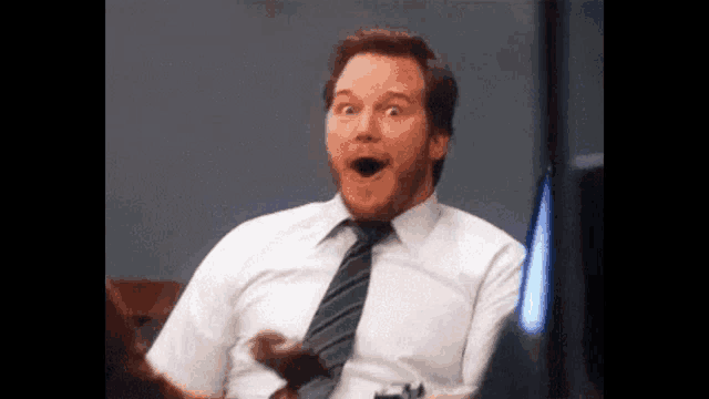 a man in a white shirt and tie is making a funny face .