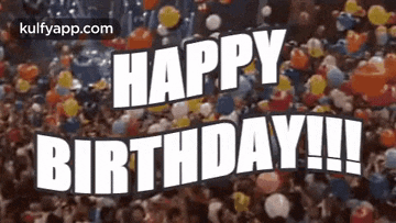 a crowd of people are celebrating a birthday with balloons in the air .