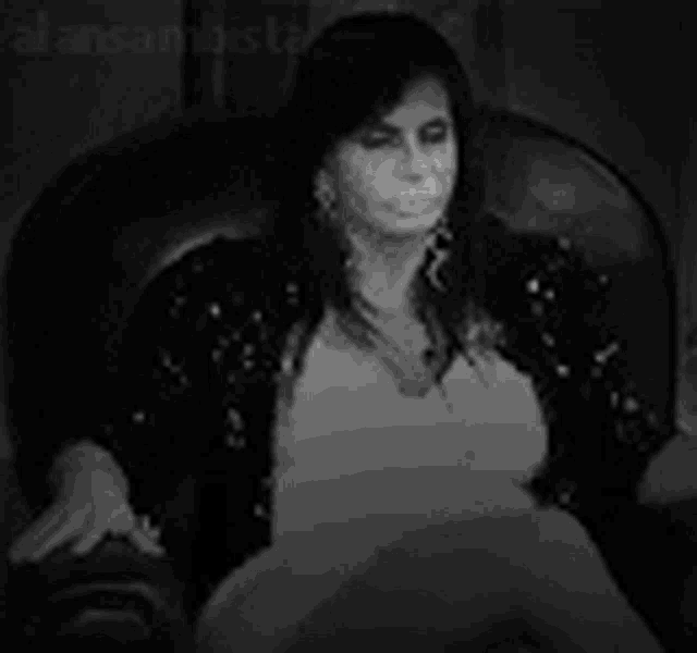 a woman is sitting in a chair with her eyes glowing brightly .