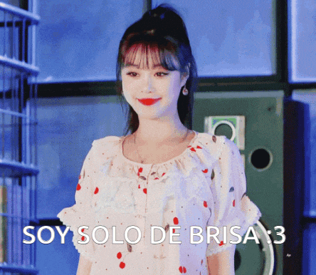 a woman in a white dress with red polka dots is standing in front of a sign that says soy solo de brisa