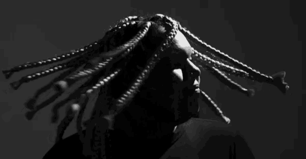 a black and white photo of a person with braids on their head