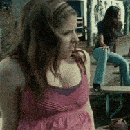 a woman in a pink tank top is looking at something