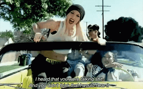 a group of women are sitting in a yellow car and one of them is saying " i heard that you were talking shit "