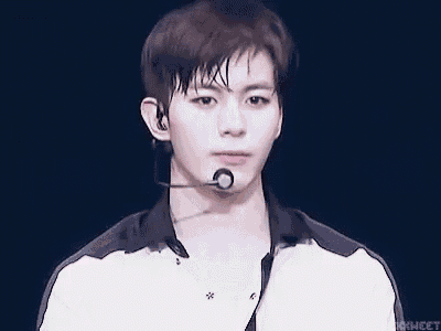a young man wearing a microphone and earphones is looking at the camera .