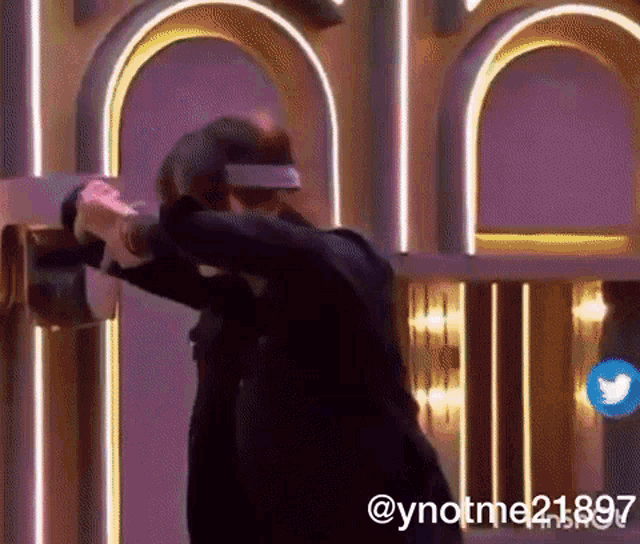 a person wearing a virtual reality headset is standing in front of a purple wall ..