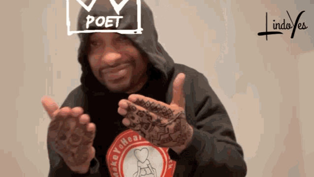 a man wearing a black hoodie has the word poet written on his face
