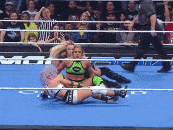 a woman in a green bikini is wrestling a man in a white shirt