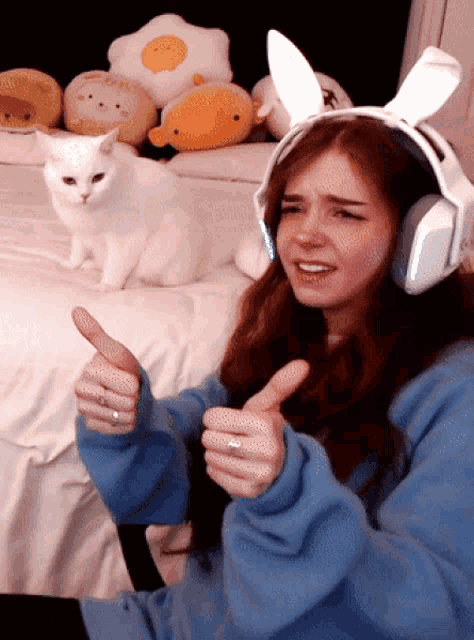 a girl wearing bunny ears giving a thumbs up