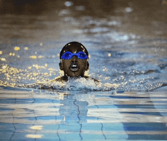 a man is swimming in a pool wearing goggles