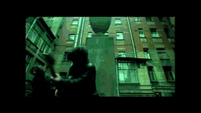 a man is playing a guitar on the edge of a building