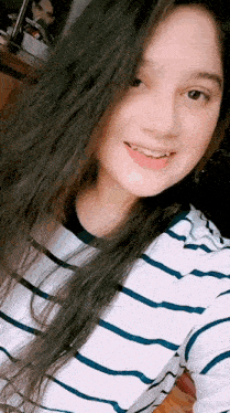 the girl is wearing a striped shirt and smiling at the camera