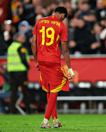 a soccer player named lamine yamal is walking on the field