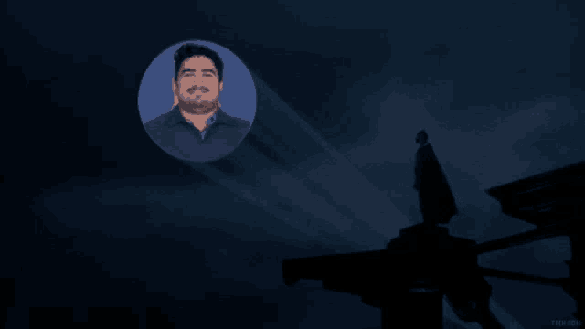 a picture of a man with a beard is projected on a dark sky