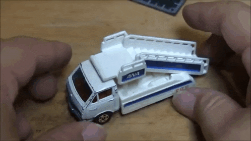a person is holding a toy truck with the word ana on the side .