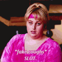 a woman wearing a pink shirt that says fake coughs slut on it