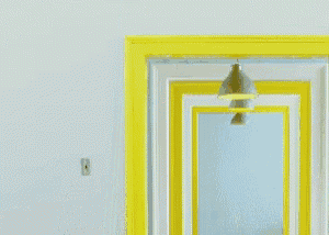 a woman in a yellow shirt is peeking out from behind a yellow door
