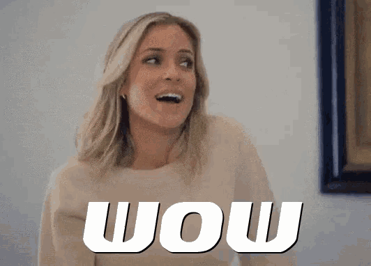 a woman is standing in front of a wall with the word wow on it