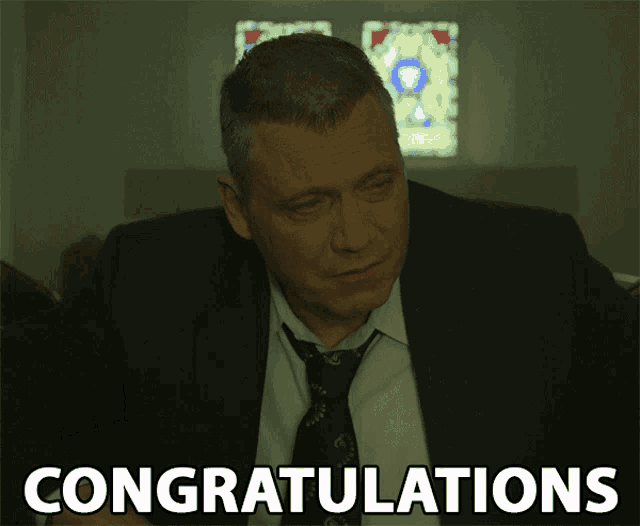 a man in a suit and tie is congratulating someone
